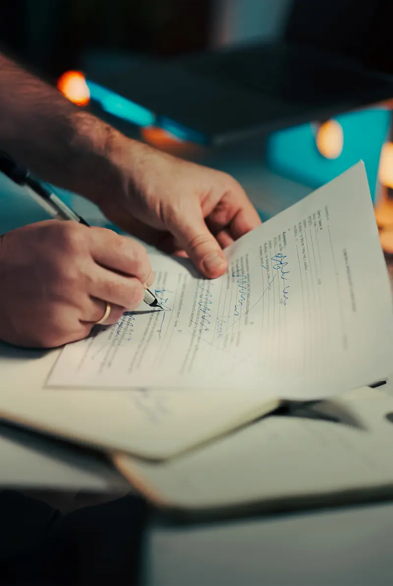 Mão assinando um documento com caneta
